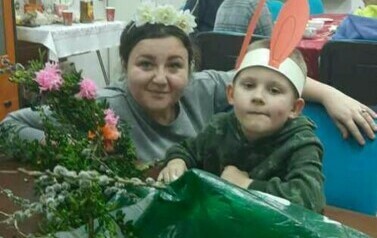 Chłopiec pozuje do zdjęcia z pracownikiem