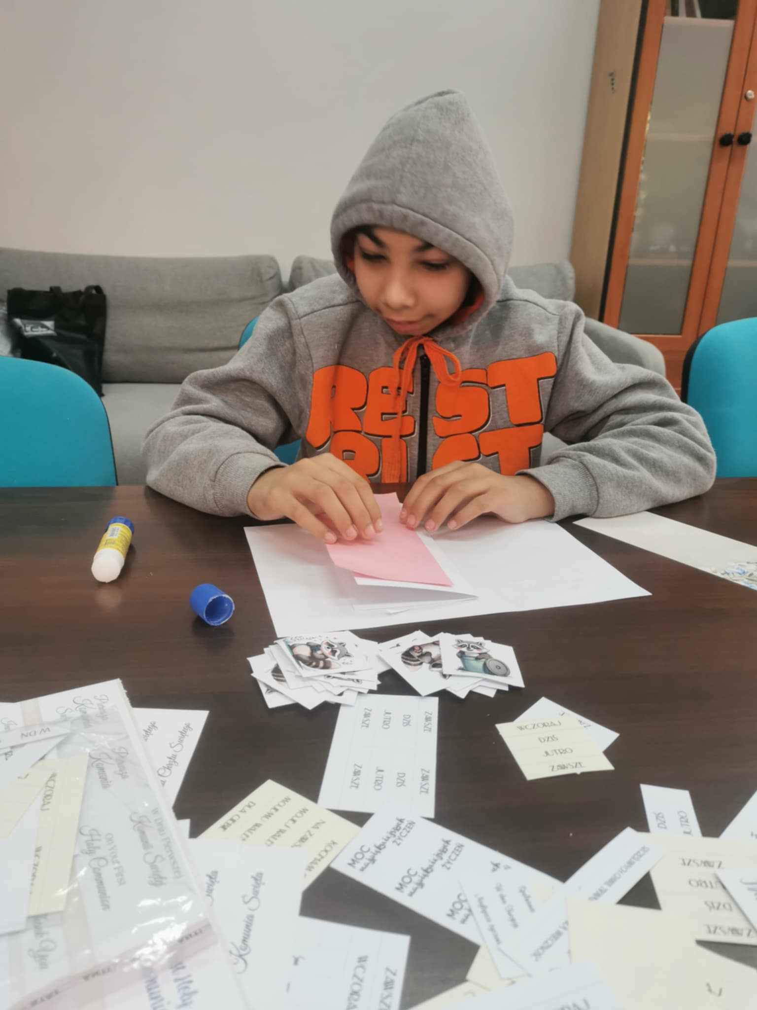 chłopiec wykonuje kartke okolicznościową